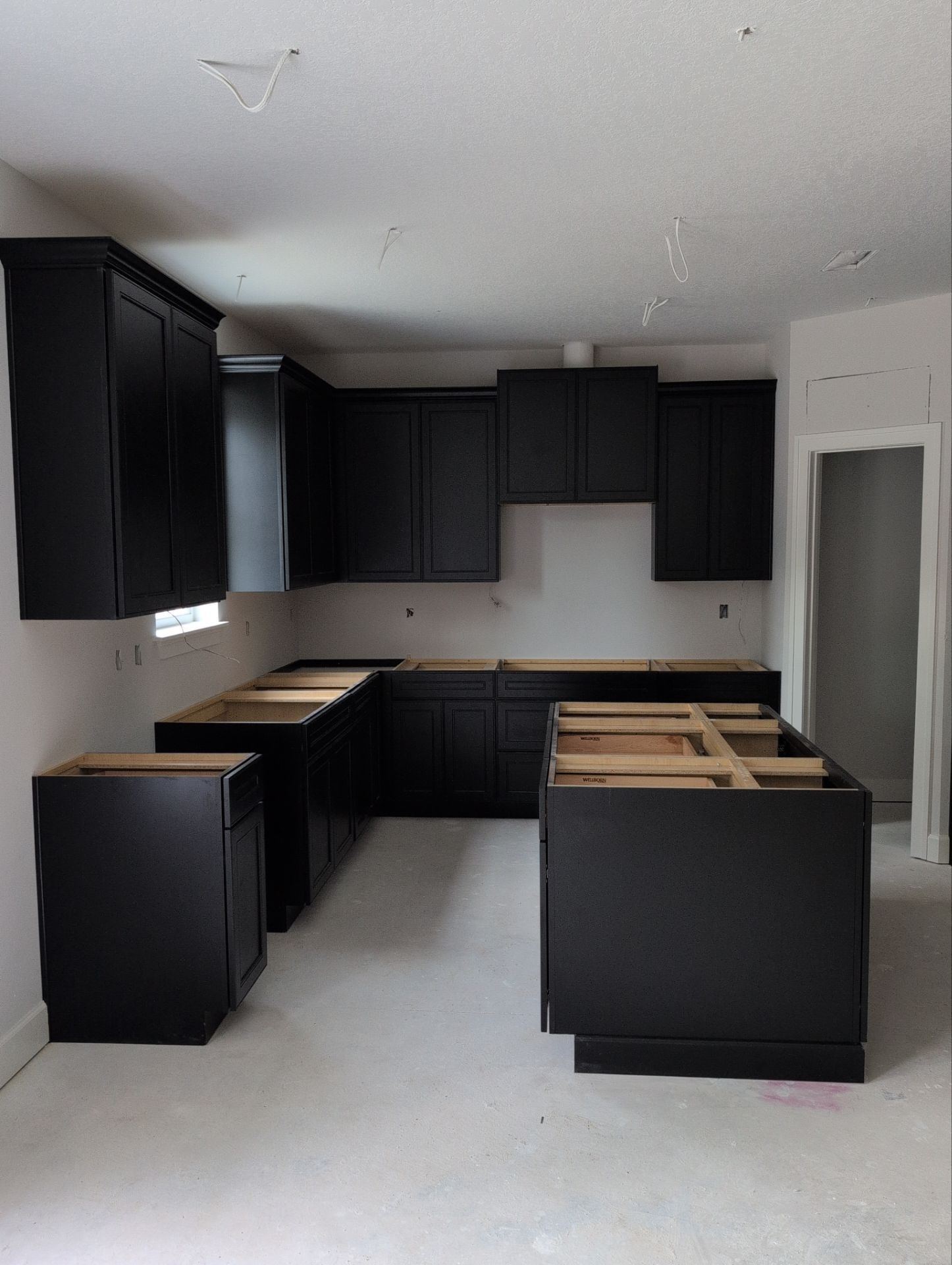 Kitchen before renovation with dark unfinished cabinets